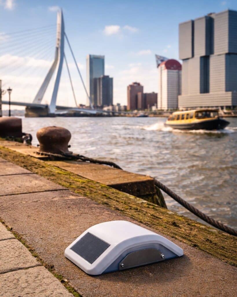 Locator Two GNSS and tilt monitoring device mounted on a quay wall near the Erasmus Bridge in Rotterdam, used for autonomous structural movement and tilt monitoring.