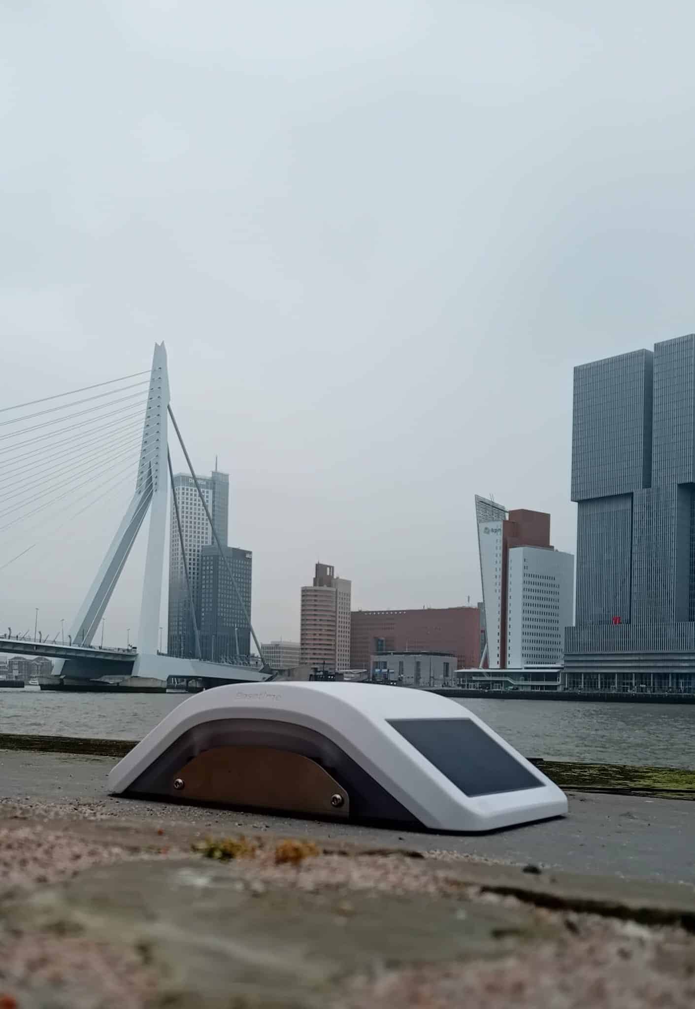 Locator Two GNSS and tilt monitoring device mounted on a quay wall beside a bridge in Rotterdam, used to measure structural movement and tilt.